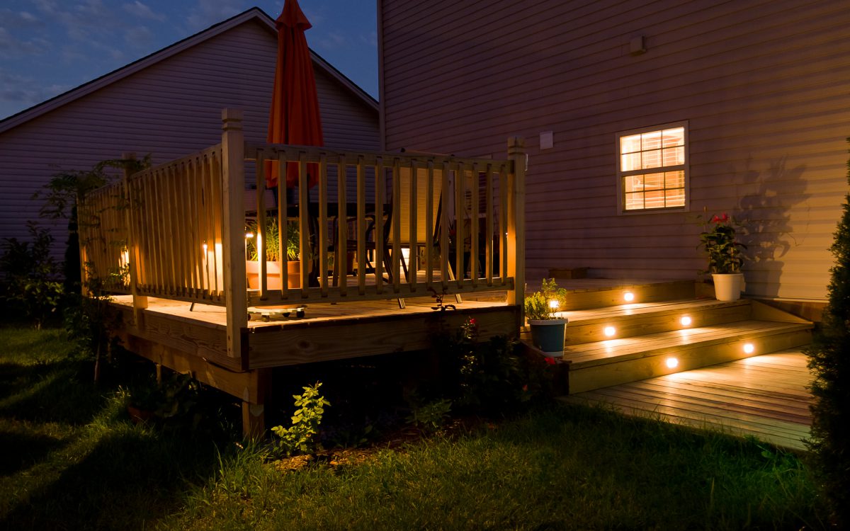 Wooden deck and patio of family home at night.